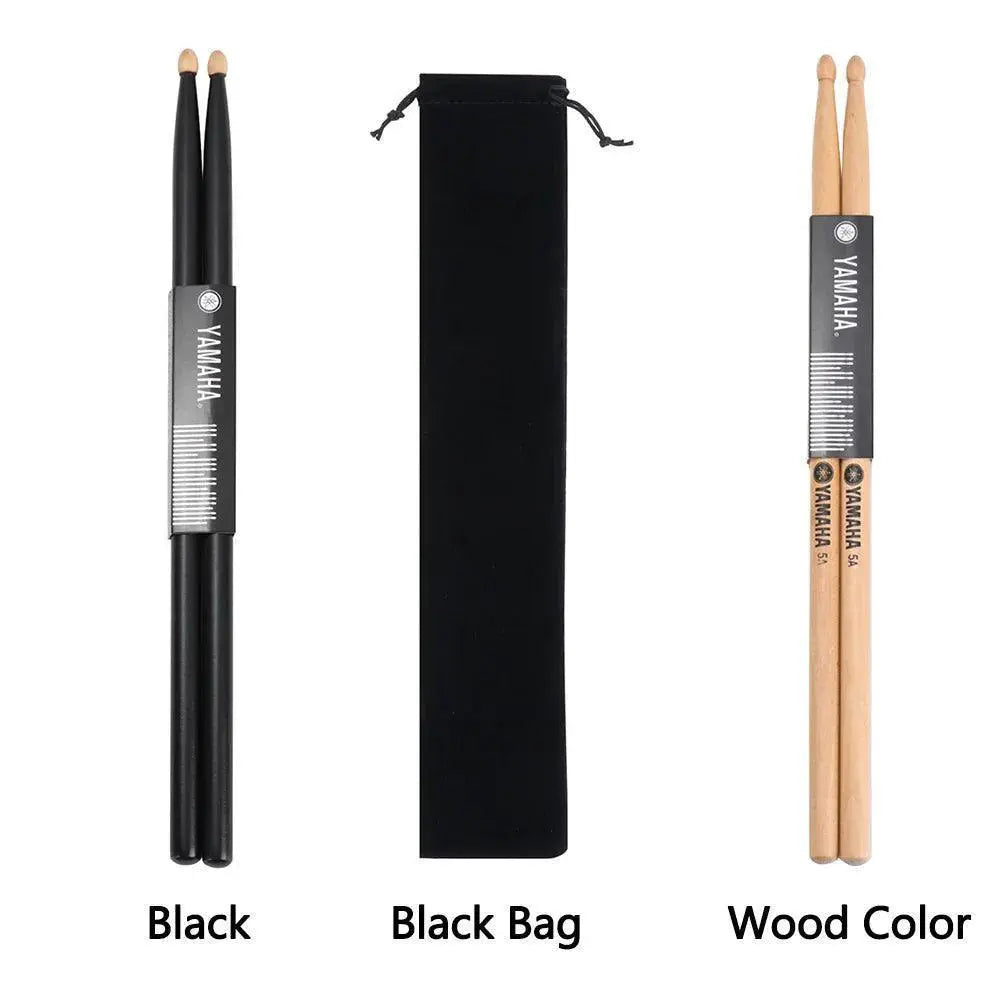 Pair of black drumsticks, wood drumsticks, and black carrying bag set on white background