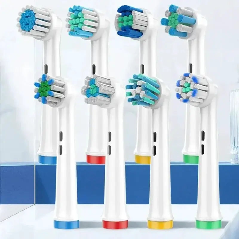 Assorted electric toothbrush replacement heads with colored rings on a clean bathroom counter at OurLum.com