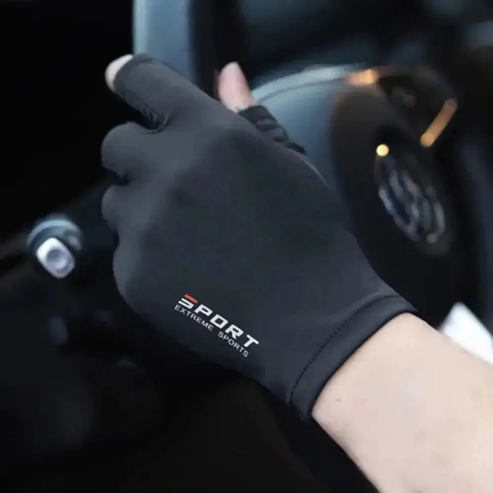 Black sport glove with 'EXTREME SPORTS' text worn while gripping a car steering wheel