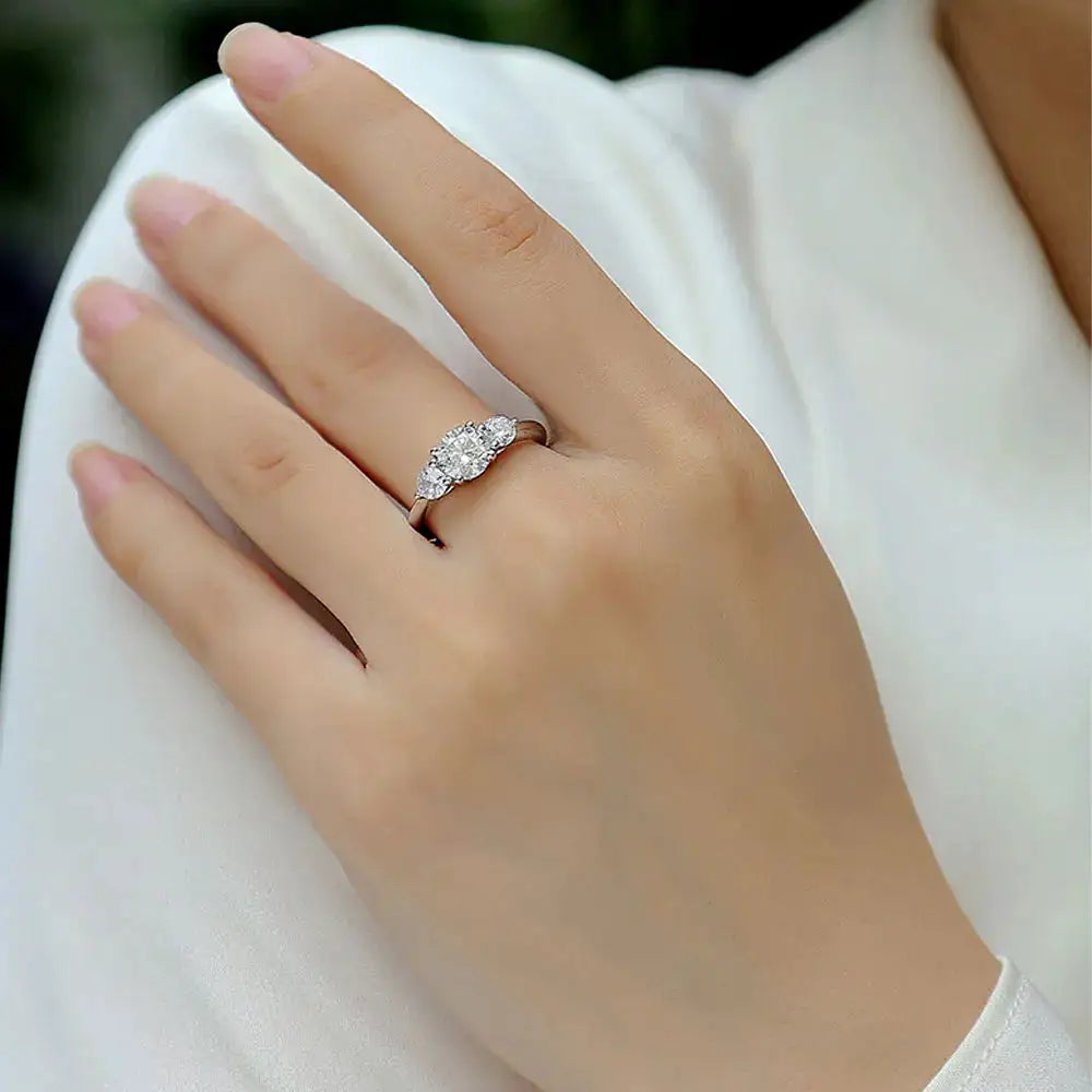 Three-stone moissanite ring with a center stone and two side accents