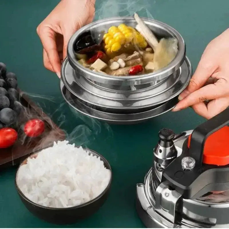 Stainless steel soup pot with steamed rice, fresh fruit, and kitchenware on green table, OurLum.com
