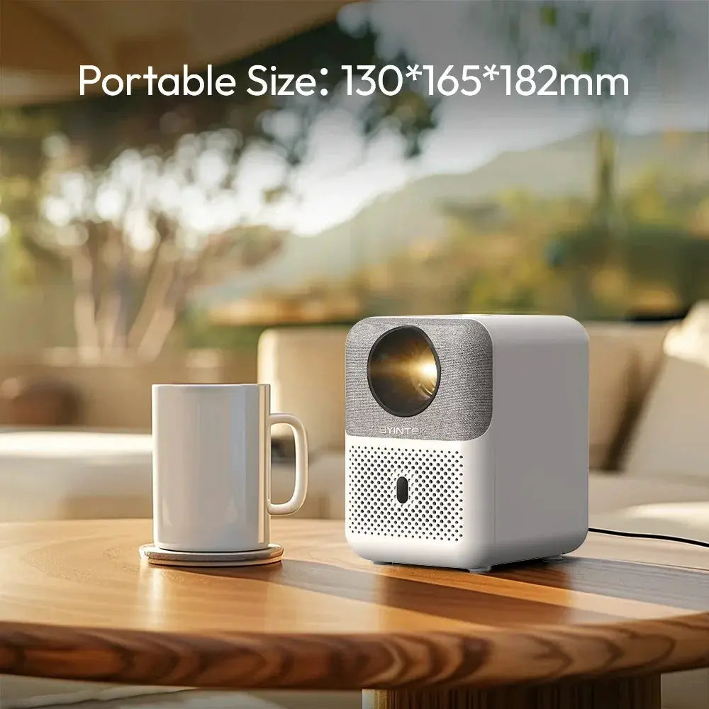 Compact portable projector and white mug on wooden table, modern indoor setting, OurLum.com tech product