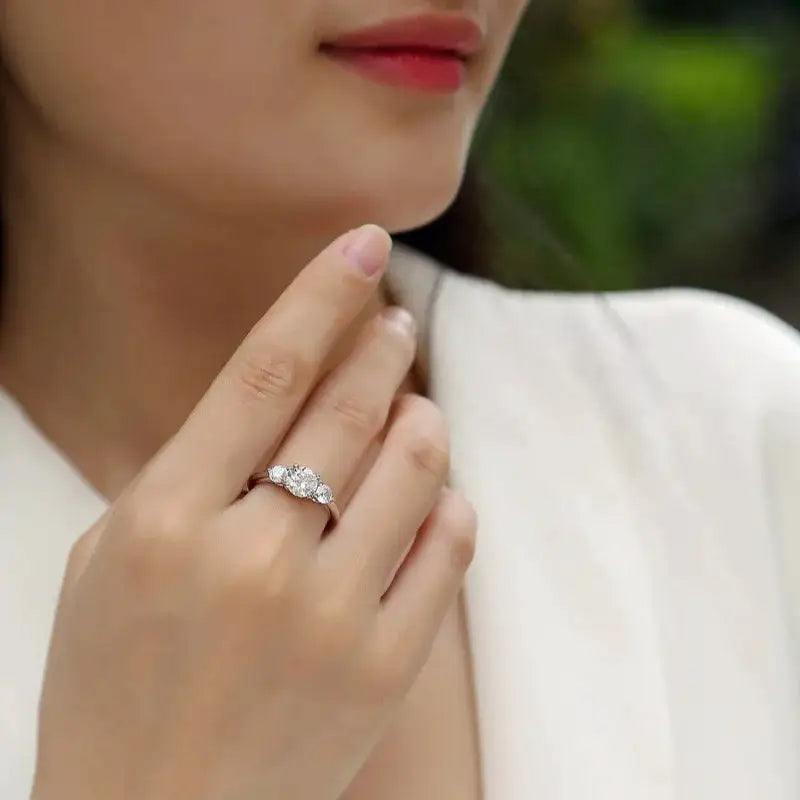 Three-stone moissanite ring with a center stone and two side accents
