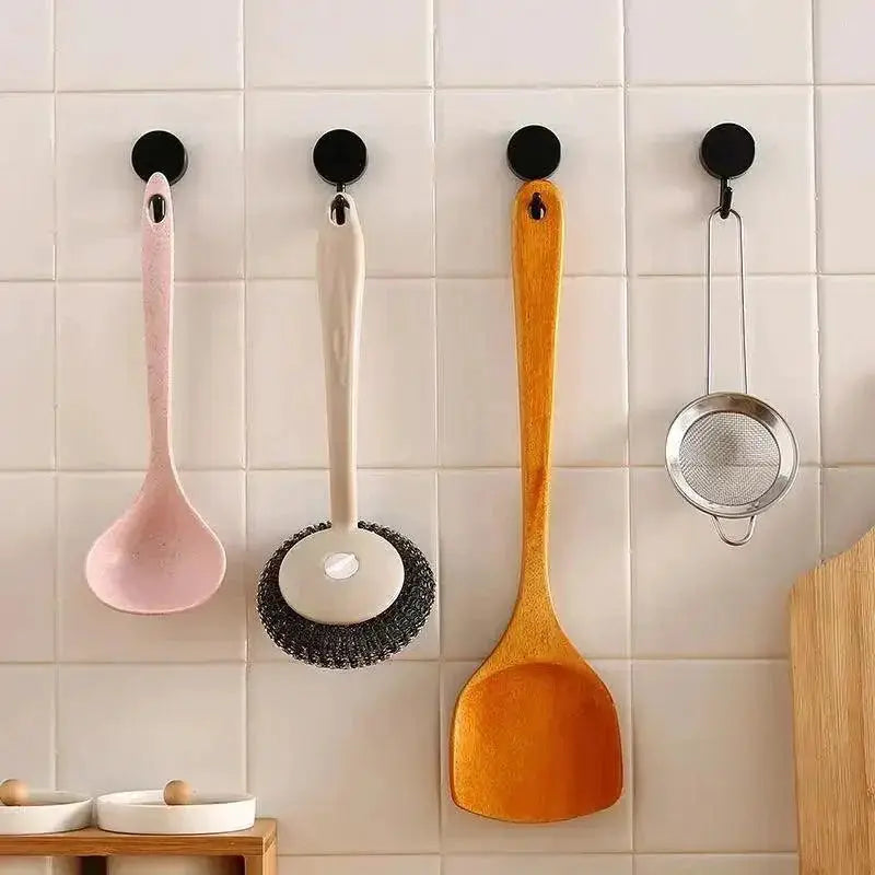 Adhesive decorative wall hooks on tiled kitchen wall holding utensils, OurLum.com
