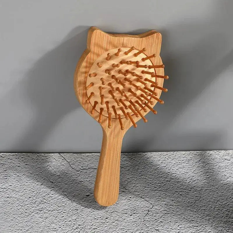 Cat-shaped bamboo hair comb for scalp massage and detangling on grey background