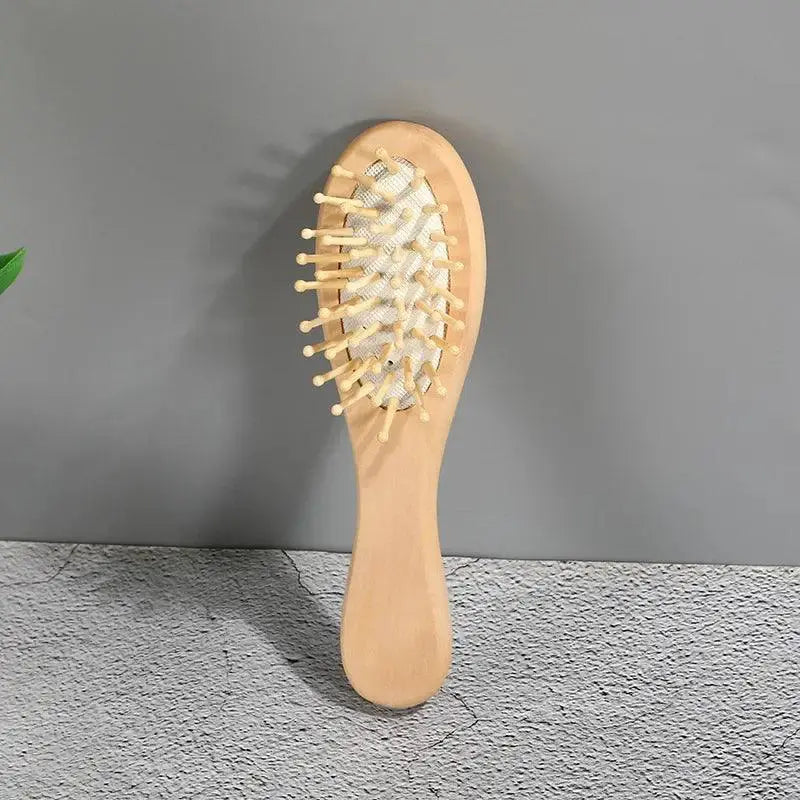 Eco-friendly bamboo hair comb with rounded bristles for scalp massage on gray background