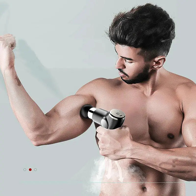 Shirtless man using black portable vibration massage gun on arm muscle