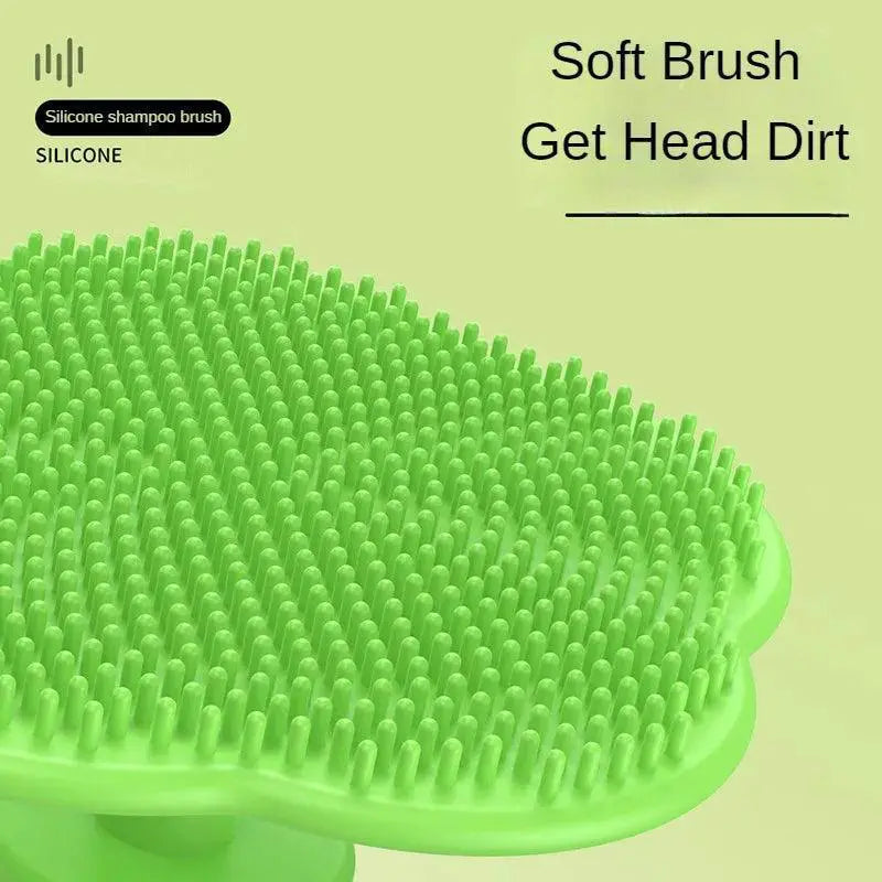Green silicone shampoo brush with soft bristles for gentle scalp cleansing.