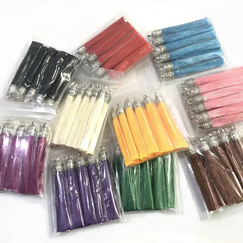 Assorted colorful silk tassel charms with silver caps for DIY jewelry, displayed in clear bags