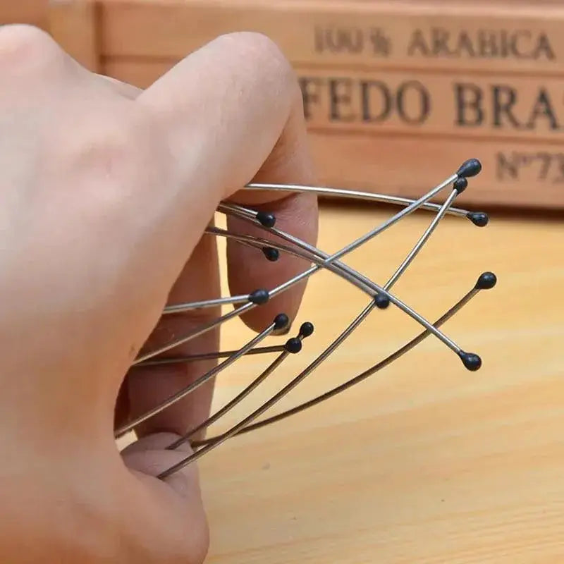 Hand holding an octopus scalp massager with metal prongs and black tips for relaxation
